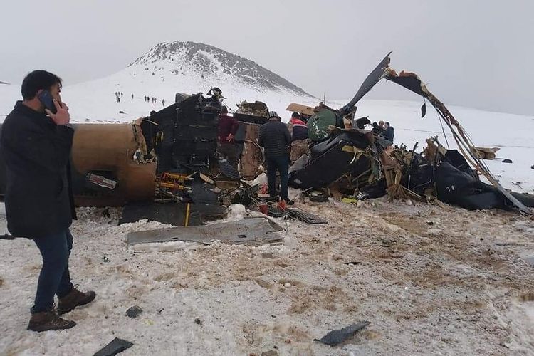 Tim penyelamat, tentara, dan warga sipil berkerumun di puing-puing helikopter militer yang jatuh di Bitlis, Turki, pada Kamis (4/3/2021). Total 11 orang tewas dalam kecelakaan ini, yaitu 10 tentara dan satu komandan.