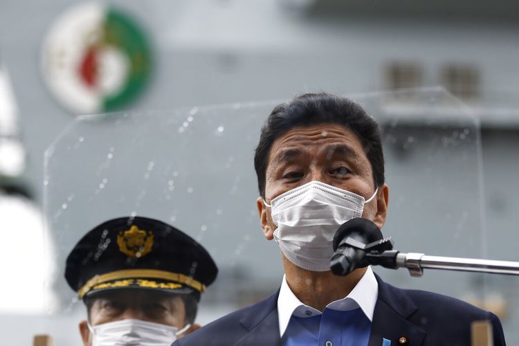 Menteri Pertahanan Jepang Nobuo Kishi, berbicara kepada anggota media setelah memeriksa kapal induk HMS Queen Elizabeth milik Angkatan Laut Kerajaan Inggris, di belakang, di pangkalan angkatan laut AS di Yokosuka, Kanagawa Prefektur, Jepang.
