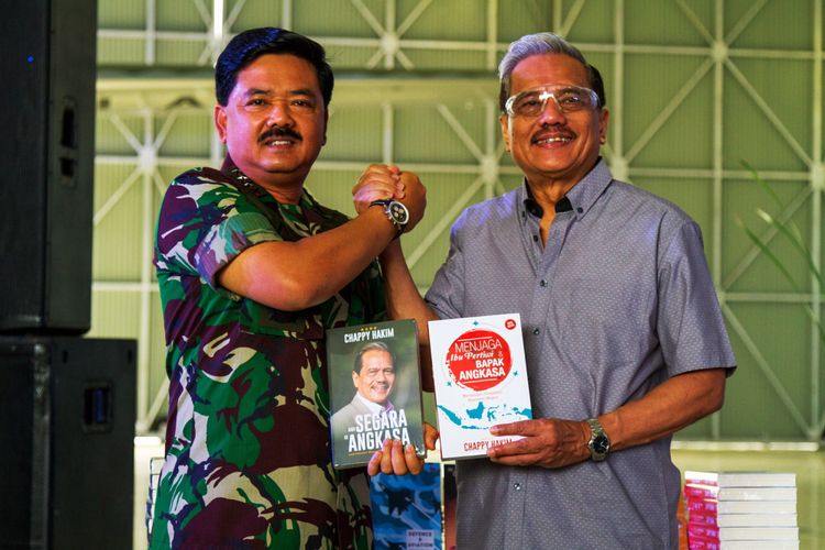 Panglima TNI Marsekal Hadi Tjahjanto (kiri) secara simbolis menerima buku yang diberikan oleh Marsekal TNI (Purn.) Chappy Hakim saat peluncuran buku dan penyerahan 100 buku kepada Angkatan Udara di Skadron Udara 31 Halim Perdanakusuma, Jakarta, Minggu (17/12/2017).