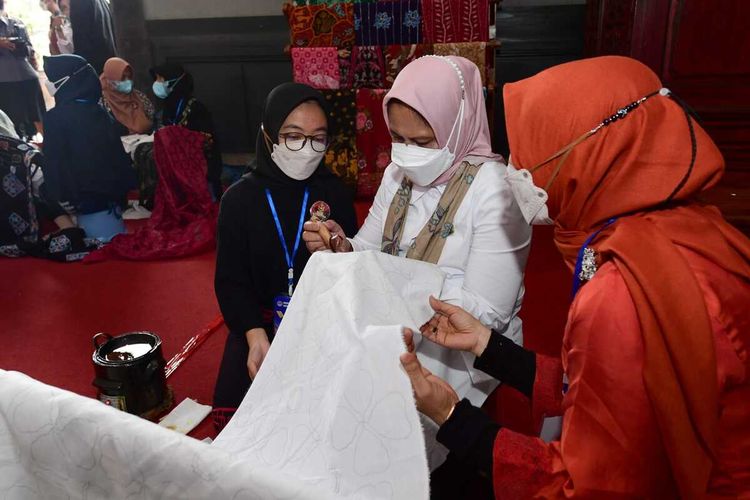 Iriana Joko Widodo mencoba menyanting di atas selembar kain dalam kunjungannya ke Pameran Dekranasda Jateng, Magelang, Selasa (31/2/2023).