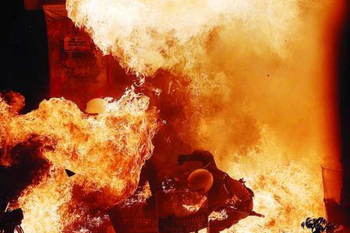 Seorang polisi antihuru-hara terkurung kobaran api dari bom molotov yang dilemparkan demonstran dalam unjuk rasa di depan gedung parlemen Yunani di Athena, Rabu (7/11). Serikat buruh melakukan mogok massal menentang penghematan anggaran pemerintah.