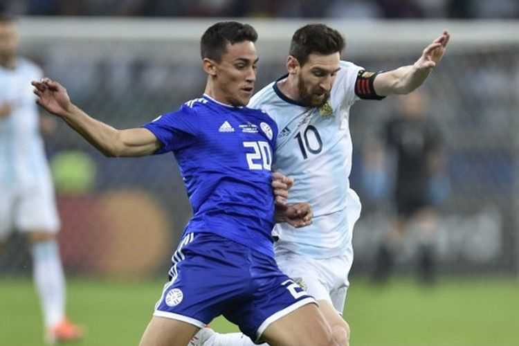 Penyerang timnas Argentina, Lionel Messi, berebut bola dengan pemain Paraguay, Matias Rojas, pada laga grup Copa America di Stadion Mineirao. Belo Horizonte, Brazil, 20 Juni 2019.