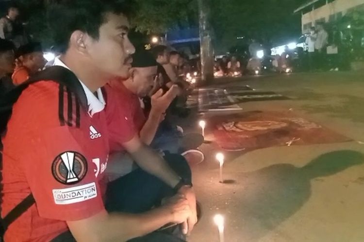 Ratusan komunitas pecinta bola di Kota Baubau, Sulawesi Tenggara menggelar doa bersama untuk korban tragedi stadion kanjuruhan di Malang, Jawa Timur pada Sabtu (1/10/2022) lalu. Doa bersama digelar di depan stadion utama di Kelurahan Lamangga, Kecamatan Murhum, Kota Baubau, Rabu (5/10/2022) malam.