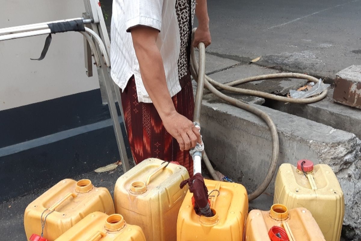 Saiful Anwar (40) sedang mengisi air PAM dalam dirigen sebab kelangkaan air bersih yang sudah melanda warga RW 09, Kelurahan Pegadungan, Kalideres, Jakarta Barat, Kamis (19/9/2019)