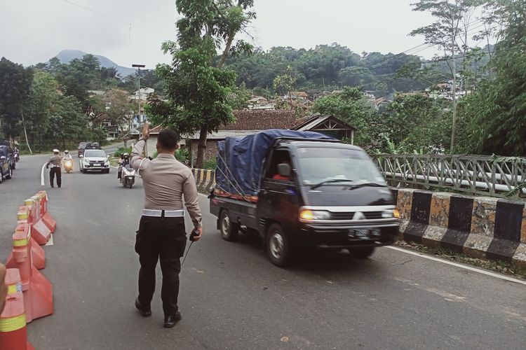 Petugas Kepolisian tengah mengatur arus lalu lintas di Pos Pengamanan Cikaledong, Nagreg, Kabupaten Bandung, Jawa Barat pada Jumat (14/4/2023).