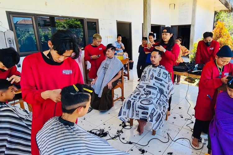 Sekelompok tukang cukur yang tergabung dalam Jumat Ganteng sedang mencukur rambut anak-anak di pesantren di Malang Raya secara gratis sebagai bentuk sedekah.