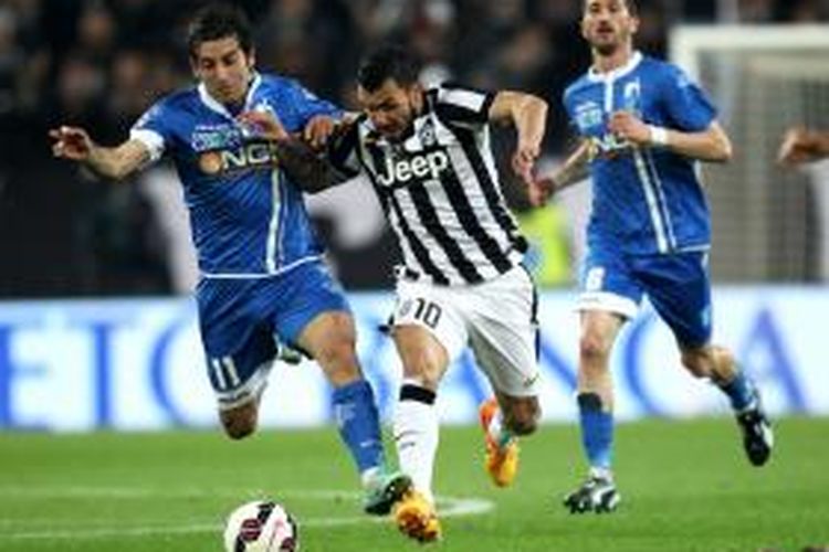 Striker Juventus, Carlos Tevez, saat berusaha berebut bola dengan pemain Empoli pada laga lanjutan Serie-A di Juventus Stadium, Sabtu (4/4/2015). 
