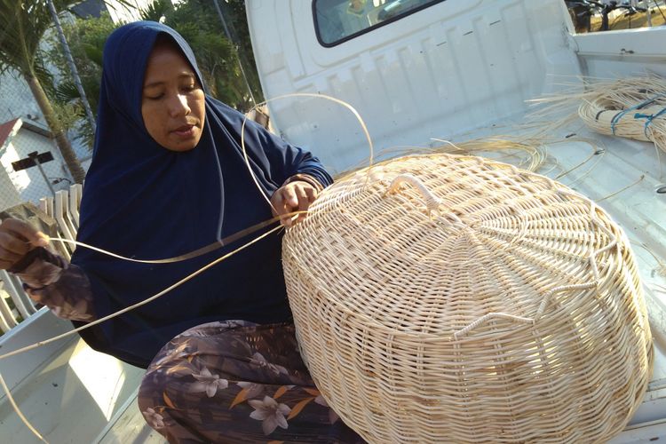 Ferdiyanti, seorang perempuan perajin rotan asal Desa Lamgaboh, Kecamatan Lhoknga, Aceh Besar, tengah menganyam rotan menjadi tudung saji.