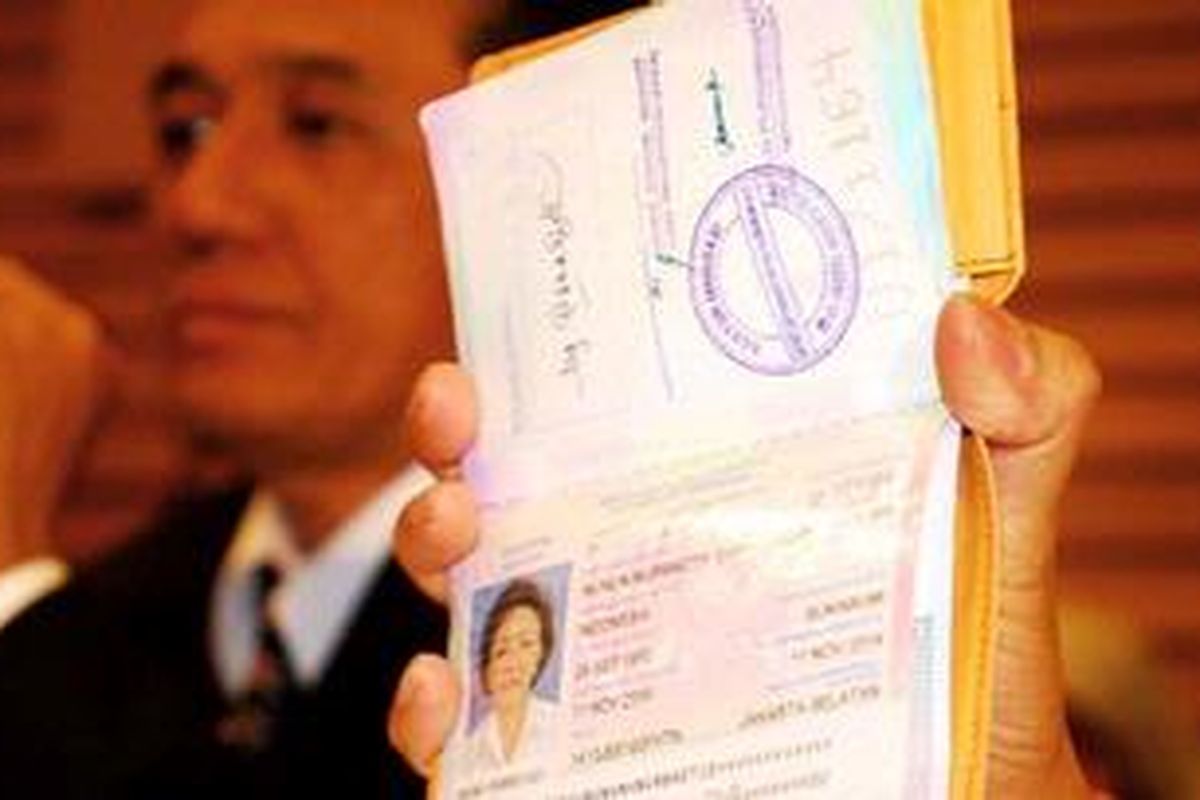 Wakil Ketua KPK, Chandra M. Hamzah menunjukan paspor atas nama Nunun Nurbaeti, tersangka kasus cek pelawat sebesar 24 miliar kepada anggota DPR dalam konferensi pers di Gedung KPK, Sabtu (10/12/2011). Nunun berhasil ditangkap di Thailand dan malam ini akan dibawa ke Rumah Tahanan Wanita Pondok Bambu.