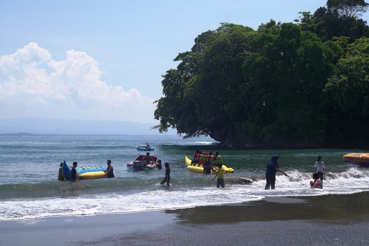 Wisatawan bermain banana boat di Pantai Batu Karas, Pangandaran, Jawa Barat. 