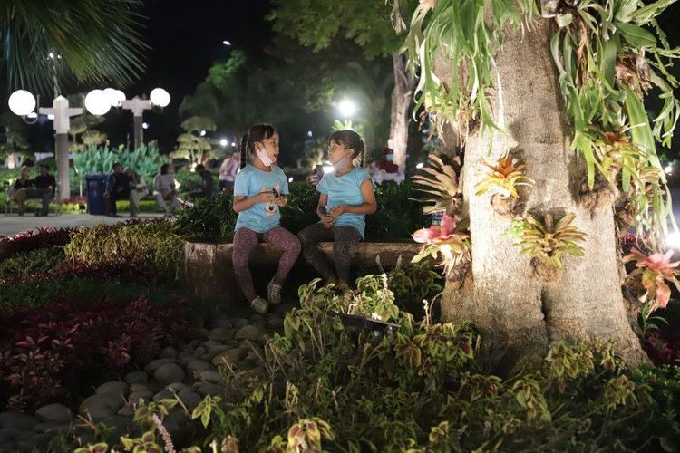 Dua anak perempuan sedang ngobrol dan bermain di Taman Surya, Kota Surabaya, Kamis (1/6/2023) malam.