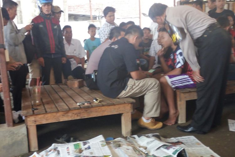 Jasad Firman Hidayat (15) seorang pelajar SMK swasta di Pasuruan ditutupi koran yang tewas mendadak seusai minum es kopi cappucino di warung kopi di Jalam Kiai Ahmad Dahlan Pohjentrek Kota Pasuruan.