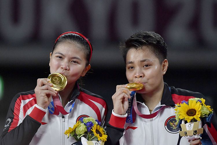 Pebulu tangkis ganda Putri Indonesia Greysia Pollii (kiri) dan Apriyani Rahayu mencium medali emas yang berhasil mereka raih untuk nomor bulutangkis ganda putri  Olimpiade Tokyo 2020 di Musashino Forest Sport Plaza, Tokyo, Jepang, Senin (2/8/2021). Greysia Pollii/Apriyani Rahayu berhasil meraih medal emasi setelah mengalahkan Chen/Jia Yi Fan dua set langsung dengan skor 21-19 dan 21-15.