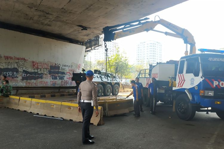Aparat Polda Metro Jaya menambah dua lapis separator movable concrete barrier (MCB) di Jalan Gatot Subroto menuju depan Gedung DPR/MPR, Jakarta Pusat, Selasa (1/10/2019), tepatnya di kolong flyover Taman Ria Senayan. 