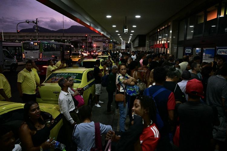 Orang-orang menunggu untuk masuk ke terminal bus Novo Rio setelah pria bersenjata yang menyandera para penumpang menyerahkan diri di Rio de Janeiro, Brasil pada Selasa (12/3/2024). Seorang pria yang melukai dua orang dan menyandera 17 penumpang bus di stasiun utama Rio de Janeiro menyerahkan diri setelah tiga jam melakukan penculikan, kata polisi, Selasa. Penculik menyerah kepada polisi militer, dia ditahan, semua sandera dibebaskan, mereka aman, kata Kolonel Marco Andrade kepada wartawan di luar terminal Novo Rio di pusat kota. 