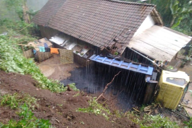 Truk pengangkut aspal hotmix yang terguling ke rumah warga Desa Kamal Kecamatan Arjasa Jember 