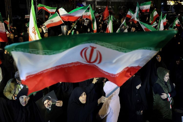 Warga Iran mengibarkan bendera negara dalam aksi mendukung angkatan bersenjata di Teheran, 25 Maret 2026.