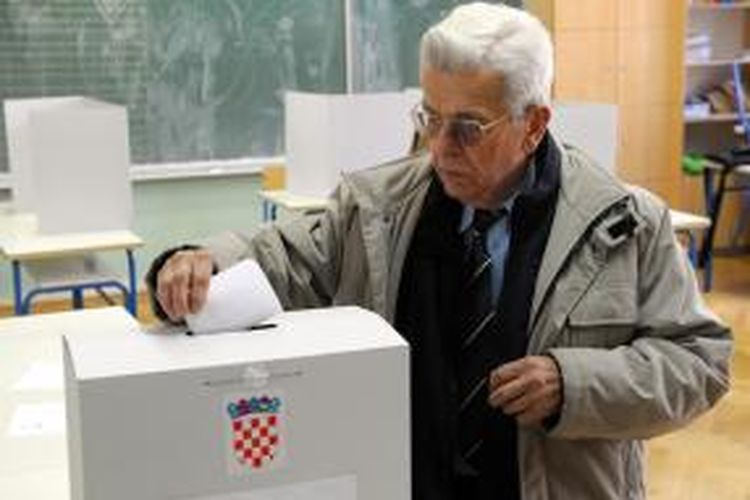 Seorang pria tengah memasukkan kartu suara dalam referendum yang digelar untuk mengesahkan pernikahan gay di Kroasia, Minggu (1/12/2013). Hasilnya, sebagian besar warga Kroasia menolak legalisasi pernikahan gay,