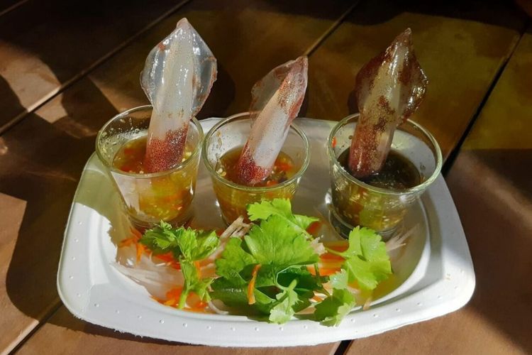 Sajian Squid Shots yang sedang tren di Thailand. Sajian ini dibuat dengan cara memasukkan cumi-cumi hidup ke gelas berisi saus pedas dan asam.