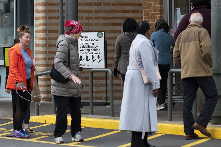 Calon pembeli mengantre dengan sistem pembatasan jarak terkait pencegahan virus corona sebelum memasuki Whole Foods di Arlington, Virginia, AS, Selasa (31/3/2020). AS kini resmi menjadi epicenter corona di dunia dengan data hingga Selasa (31/3/2020) terdapat 163.429 kasus positif dan korban meninggal 3.148 orang, melebihi Italia, China, dan Spanyol.