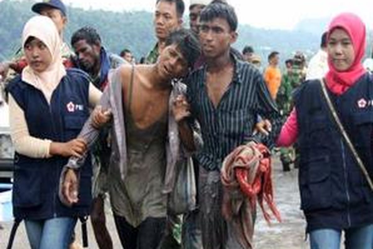 Dua warga Myanmar yang kelelahan setelah terdampar di perairan Ujong Bak U, Sabang, Aceh, Rabu (7/1) dipapah relawan Palang Merah Indonesia (PMI) menuju lapangan Dermaga Lanal untuk mendapatkan perawatan lebih lanjut.