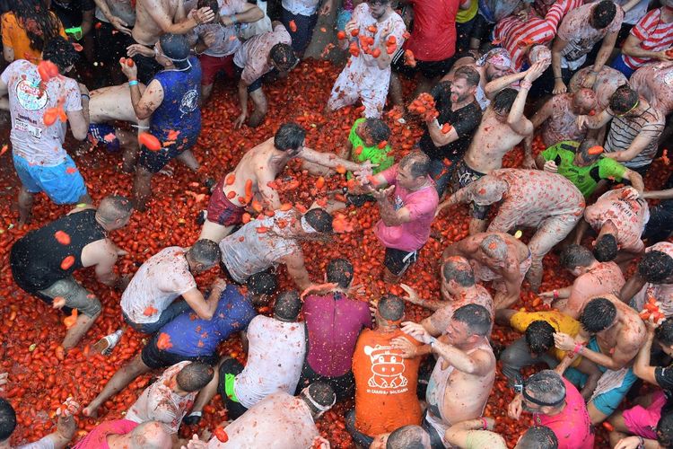Orang-orang yang bersuka ria dalam festival La Tomatina alias perang tomat di Kota Bunol, Spanyol, pada 31 Agustus 2022. Pesta ikonik, yang disebut sebagai perang makanan terbesar di dunia telah menjadi daya tarik utama bagi orang asing, khususnya dari Inggris, Jepang, dan AS. 