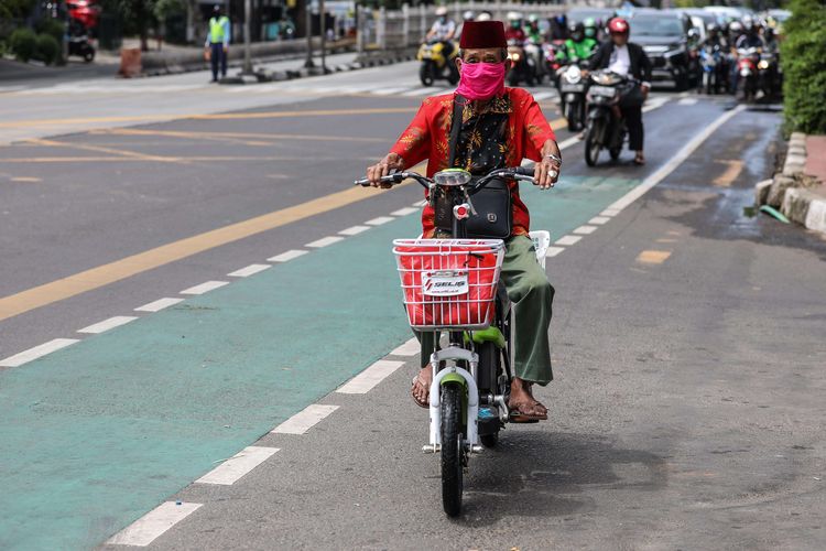 Warga menggunakan masker saat mengendarai sepeda listrik di kawasan Mampang Prapatan, Jakarta Selatan, Senin (6/4/2020). Kebijakan wajib masker itu  tertuang dalam Seruan Gubernur Daerah Khusus Ibu Kota Jakarta Nomor 9 Tahun 2020 Tentang Penggunaan Masker Untuk Mencegah Penularan Corona Virus Disease (Covid-19).