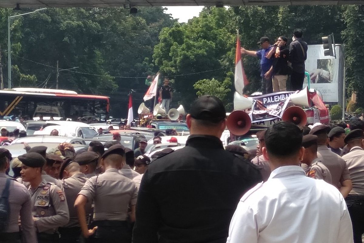 Seorang orator mengumandangkan adzan Dzuhur saat demo di depan kantor Gojek di Jalan Iskandarsyah, Melawai, Jakarta Selatan, Senin (5/8/2019)