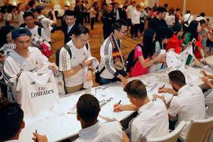 Para pemain Real Madrid tengah melayani permintaan fans di Guangzhou yang meminta tanda tangan, Minggu (26/7/2015). 