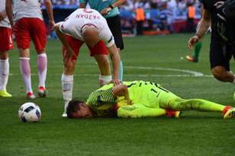 Penjaga gawang Polandia, Wojciech Szczesny, mengalami cedera saat melawan Irlandia Utara pada partai Piala Eropa Grup C di Stade de Nice, 12 Juni 2016.