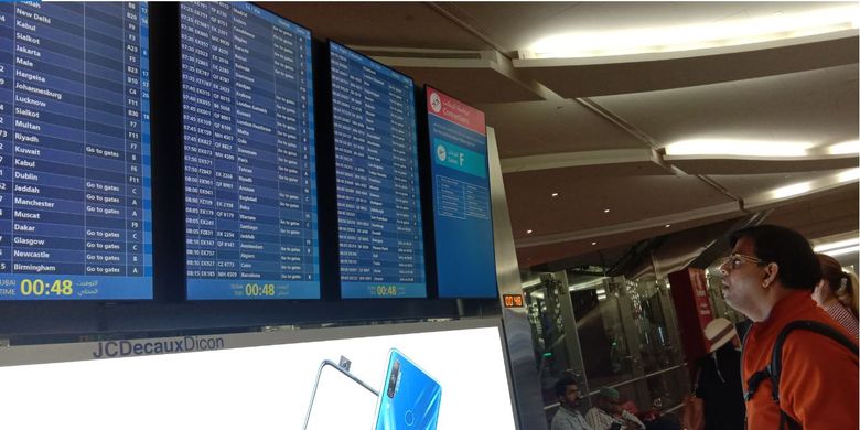 Seorang penumpang melihat monitor untuk mencari tahu informasi penerbangannya di Dubai International Airport (DXB).