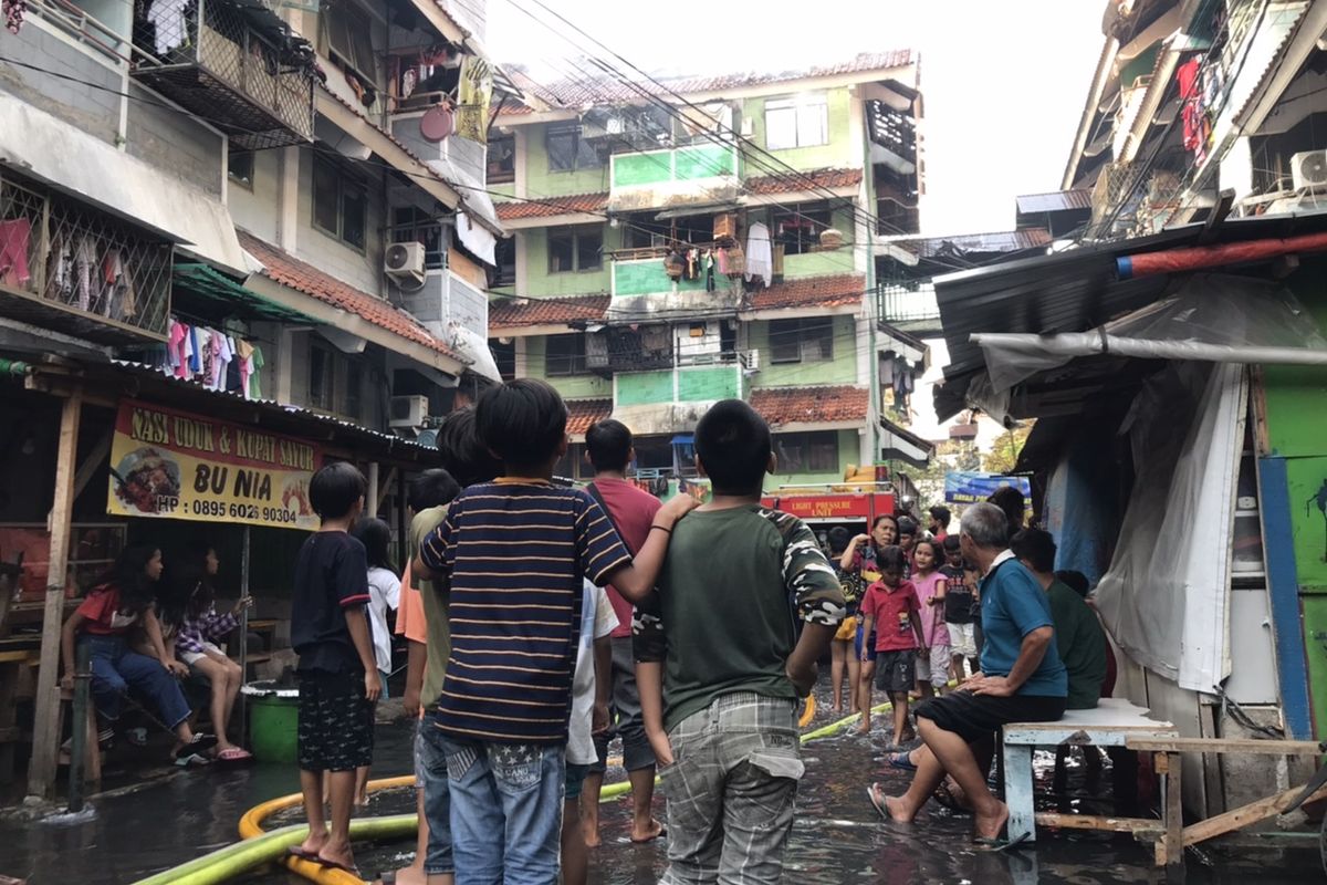 Warga berada di sekitar Rumah Susun Tanah Tinggi, Johar Baru, Jakarta Pusat yang terbakar pada Minggu (10/10/2021) sore.