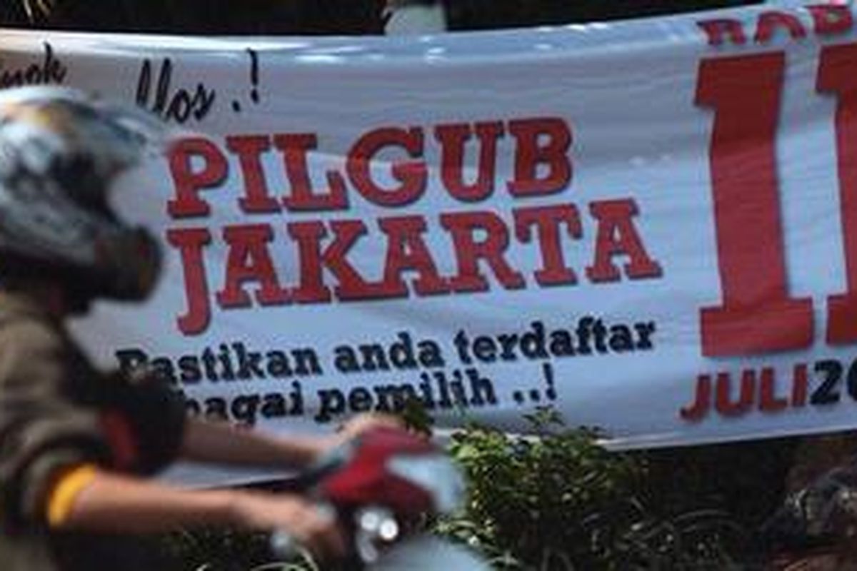 Pengendara motor berhenti di depan  spanduk sosialisasi pemilihan gubernur DKI Jakarta yang terpasang di Kawasan Grogol, Jakarta Barat, Senin (5/3/2012). Pemilihan gubernur DKI sendiri dijadwalkan akan dilaksanakan 11 Juli 2012.