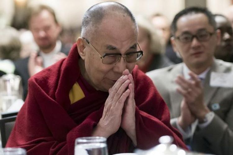 Pemimpin spiritual Tibet Dalai Lama menangkupkan kedua tangannya saat diperkenalkan dalam acara doa dan sarapan pagi di Washington DC, AS, Kamis (5/2/2015). Kehadiran Dalai Lama dalam acara ini menuai protes dari pemerintah China.