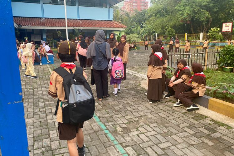 Guru di Sekolah Dasar Negeri (SDN) Pasar Minggu 03 Pagi tengah menyapa murid di depan gerbang pada hari pertama masuk sekolah di Jakarta pada Rabu (12/7/2023).