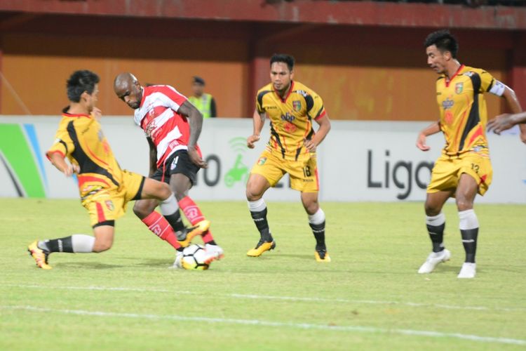 Steiker Madura United, Greg Nwokolo mencoba melewati adangan dua pemain Mitra Kukar dalam pertandingan Liga 1 pekan 21 di Stadion Gelora Ratu Pamelingan, Kamis (13/9/2018)