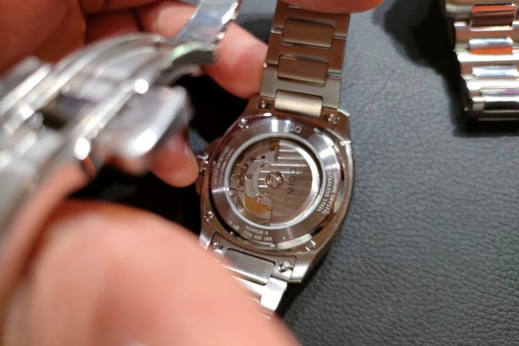 Pegas keseimbangan Nivachron memastikan ketahanan yang sangat baik terhadap guncangan dan medan magnet pada jam tangan Mido Multifort TV Big Date. Komponen ini juga dapat dilihat melalui bagian belakang arloji, dengan rotor yang terpatri merek Mido.
