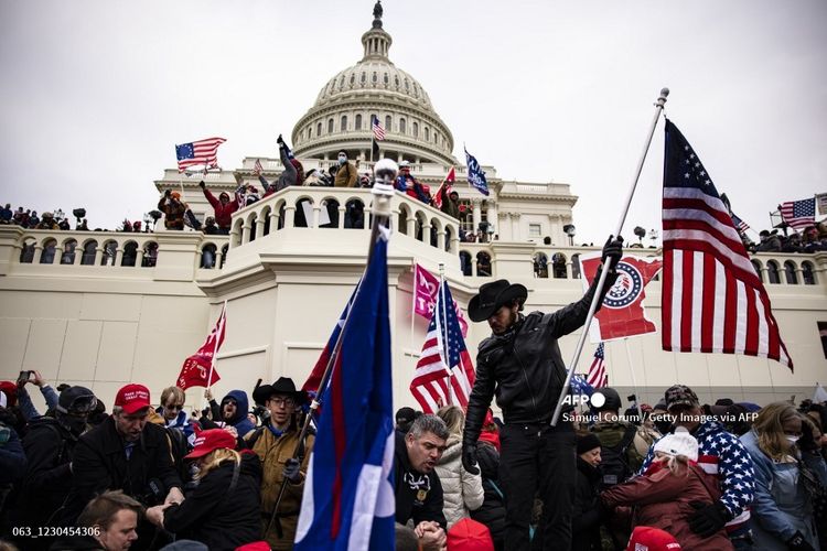 Massa pendukung Presiden Amerika Serikat (AS) Donald Trump menyerbu Gedung Capitol di Washington DC, 6 Januari 2021. Pendukung Trump berkumpul di ibu kota untuk menghentikan Kongres AS mengesahkan kemenangan Joe Biden.