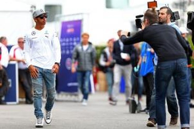 Pebalap Mercedes asal Inggris, Lewis Hamilton, berjalan menyeberangi paddock Sirkuit Gilles Villeneuve jelang GP Kanada, Kamis (5/6/2014).