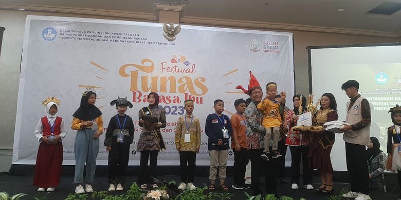 Akhayarul Iksan (berbaju kuning dan digendong), siswa kelas V SD Negeri 56 Kota Parepare yang menjadi juara pertama kategori Dongeng Putra untuk rumpun bahasa Bugis dalam FTBI Sulselbar 2023 di Makassar, Sulawesi Selatan.