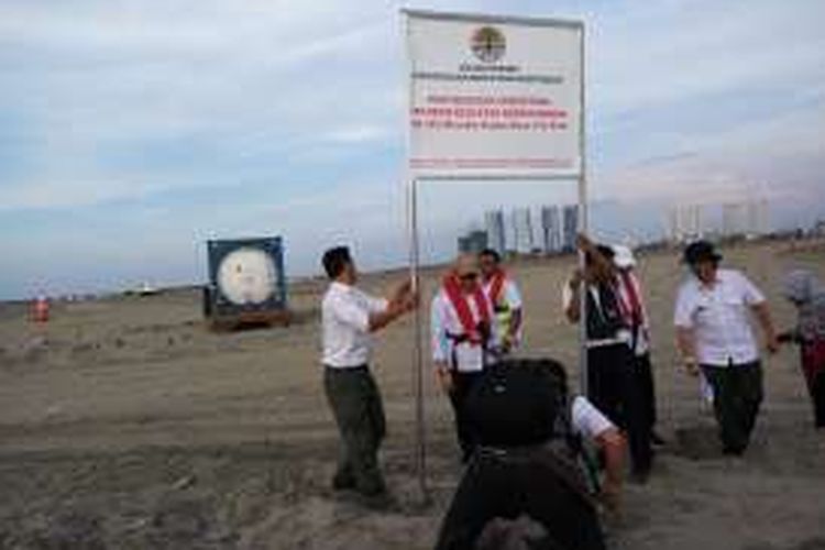 Sejumlah petugas dari Kementerian Lingkungan Hidup dan Kehutanan saat memasang plang penghentian proyek reklamasi di Pulau G pada Rabu (11/5/2016).