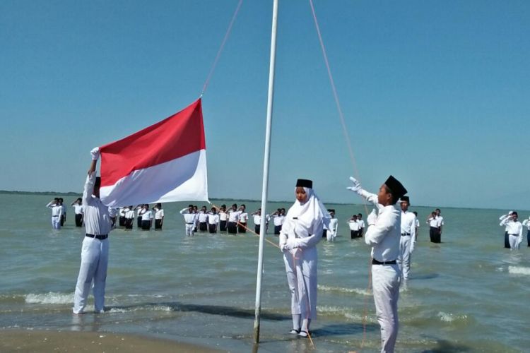 Petugas pengibar bendera menaikan sang merah putih,  dalam upacara peringatan HUT Kemerdekaan RI ke 73 di Pantai Onggojoyo,  Kecamatan Wedung,  Kabupaten Demak,  Jateng,  Jumat (17/8/2018)