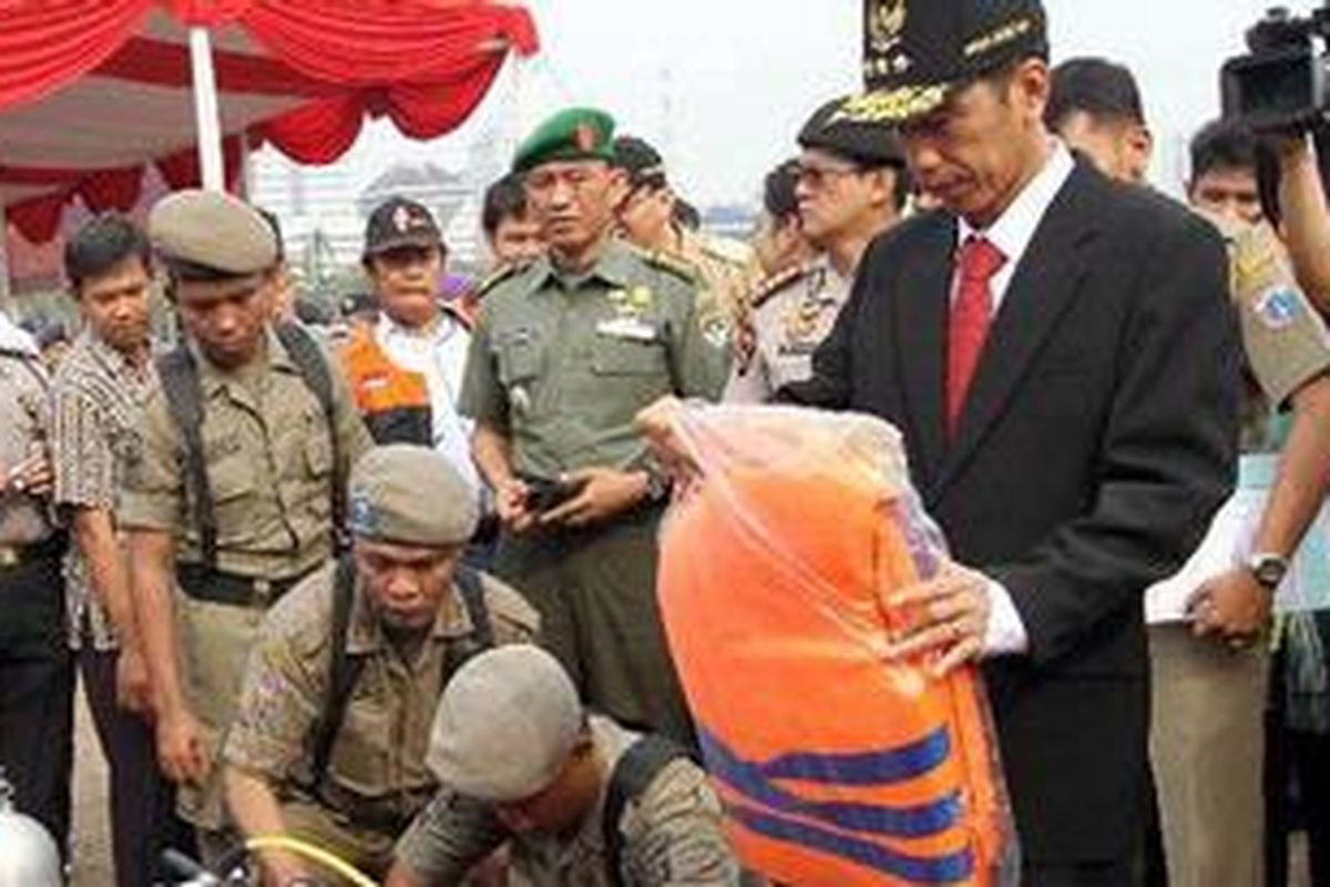 Gubernur DKI Jakarta, Joko Widodo (Jokowi), memeriksa perlengkapan penanganan banjir Satpol PP pada apel kesiagaan banjir di lapangan Monas Jakarta Pusat, Selasa (6/11/2012). Apel ini dilakukan untuk mengetahui kesiapan menghadapi banjir pada musim hujan tahun ini. 