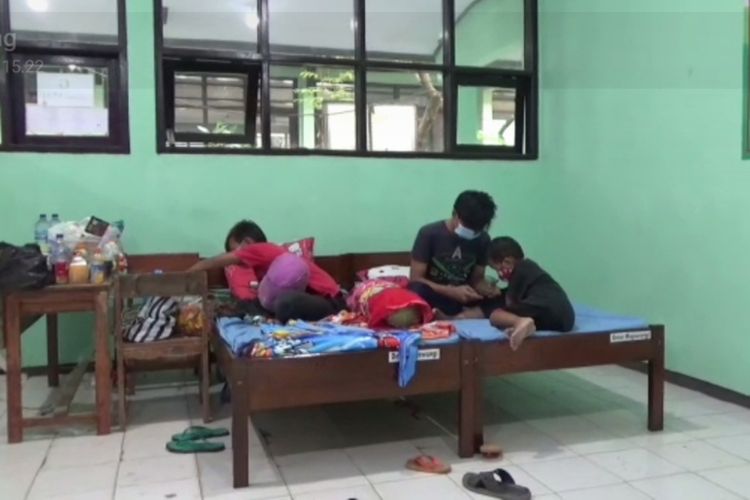 Sepeninggal sang ibu yang meninggal karena positif Covid-19, tiga anak tinggal di rumah isolasi terpusat di SMPN 1 Mojowarno, Kabupaten Jombang, Jawa Timur.