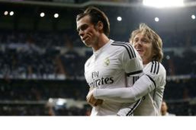 Gareth Bale (kiri) mendapat sambutan dari Luka Modric setelah mencetak gol pertama Real Madrid ke gawang Levante, Minggu (15/3/2015).