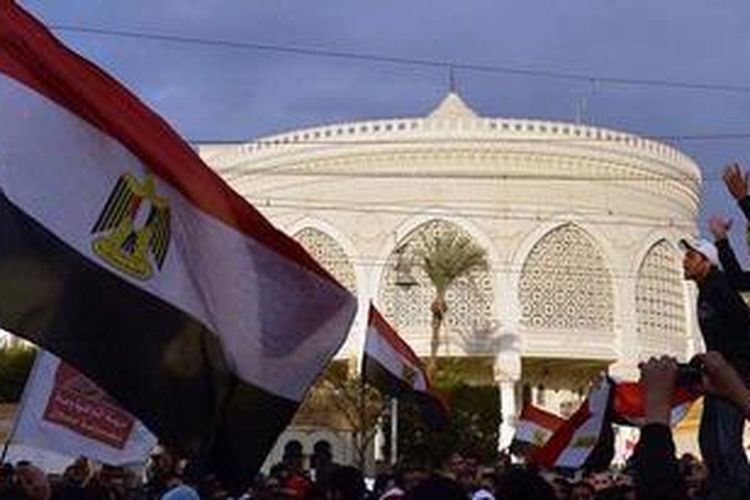 Para penentang Presiden Mohammed Mursi dan Ikhwanul Muslimin, membawa bendera nasional saat berunjuk rasa di depan istana kepresidenan di Kairo, Mesir, Jumat (1/2/2013).
