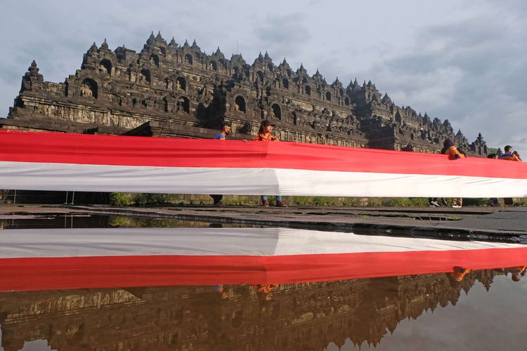 Peserta membentangkan bendera merah putih mengelilingi Candi Borobudur saat peringatan Hari Lahir Pancasila di Taman Wisata Candi (TWC) Borobudur, Magelang, Jawa Tengah, Rabu (1/6/2022). Kegiatan pembentangan bendera sepanjang satu kilometer yang diikuti oleh berbagai elemen masyarakat tersebut sebagai wujud semangat persatuan dan kesatuan bangsa dalam menjaga dasar negara Pancasila.