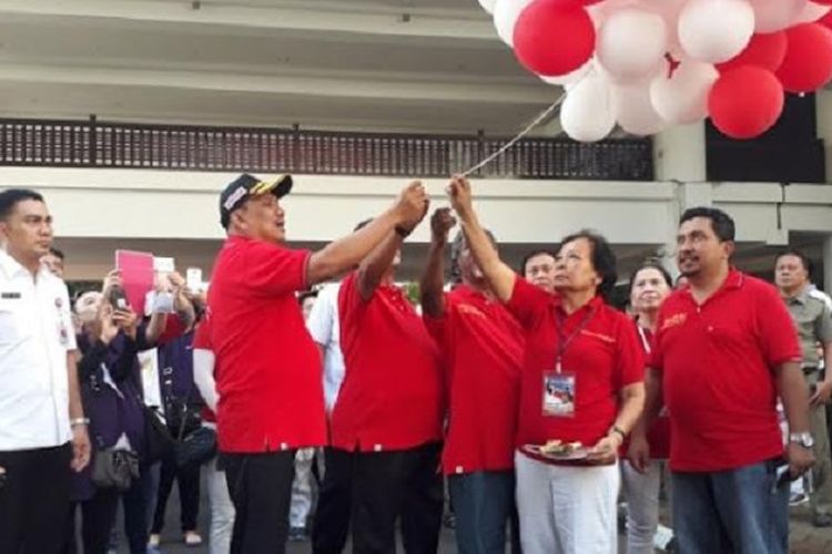 Gubernur Sulawesi Utara Olly Dondokambey (memakai topi dan memegang balon) melepas peserta Kirab  Kasih 73 di depan lobi Kantor Gubernur Sulut, Rabu (15/8/2018).