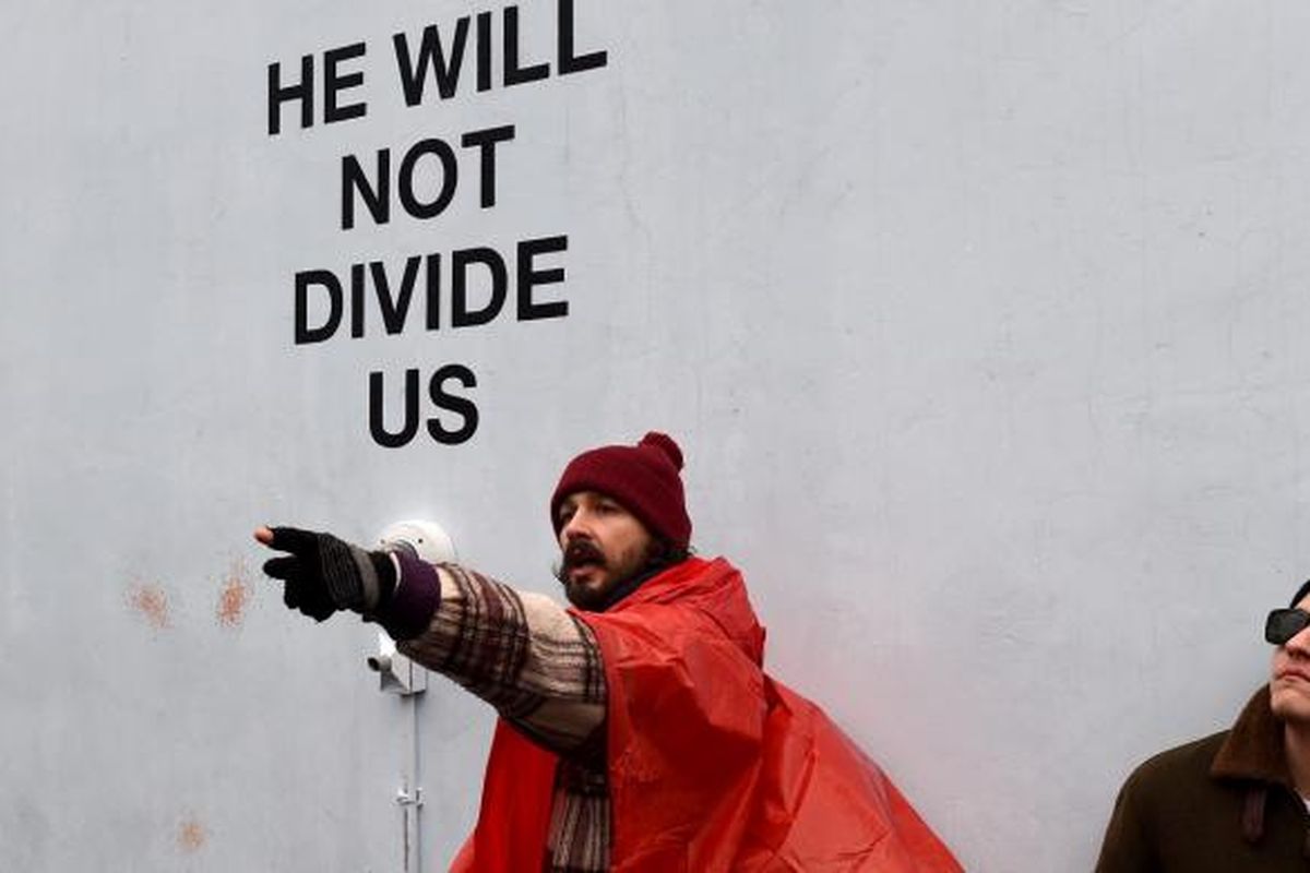 Aktor Shia LaBeouf (bertopi merah) melakukan unjuk rasa menentang Donald Trump di Museum of the Moving Image di Astoria, Queens, New York, Selasa (24/1/2017).