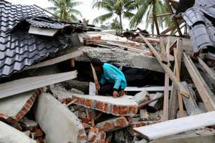 Situasi rumah yang runtuh akibat gempa di Desa Kuta Pangwa, Kecamatan Trienggadeng, Pidie Jaya, Aceh, Jumat (9/12/2016). Desa Kuta Pangwa adalah titik desa terparah dan menyebabkan puluhan rumah warga hancur dan memakan 15 orang dari 9 kepala keluarga.

